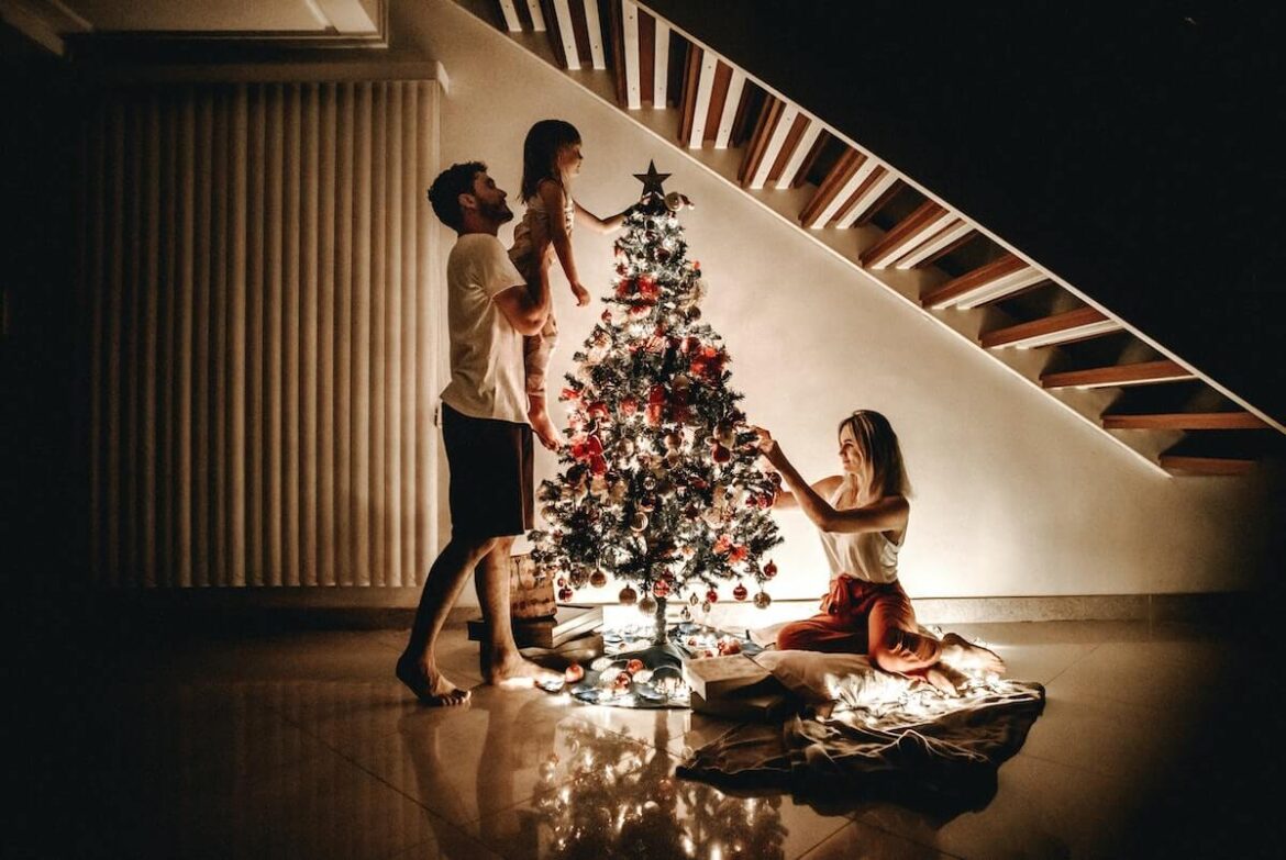 クリスマスツリーの飾り付けをしている家族