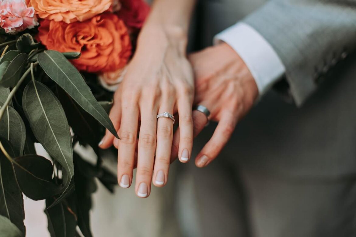 結婚指輪をはめているカップルの手